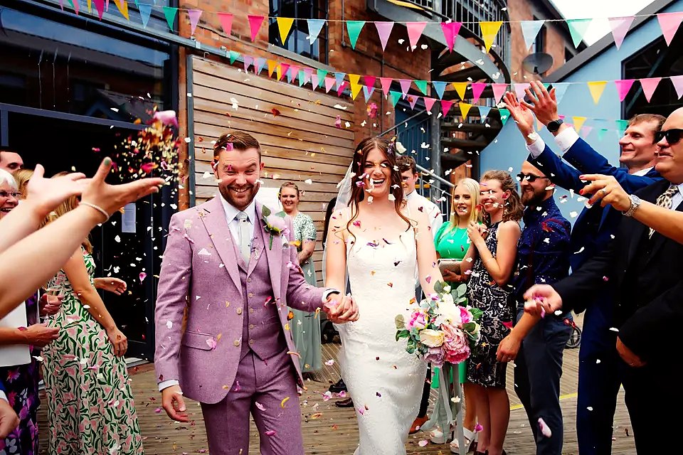 Bride and groom during a colourful confetti send-off